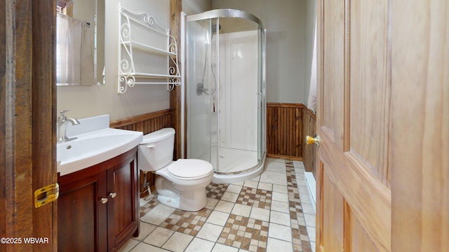 bathroom with walk in shower, vanity, toilet, and wood walls