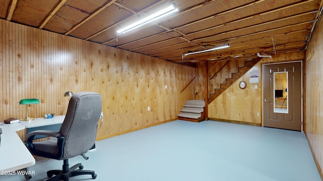 unfurnished office featuring concrete floors and wood walls