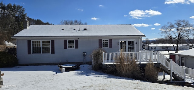 snow covered property featuring a wooden deck