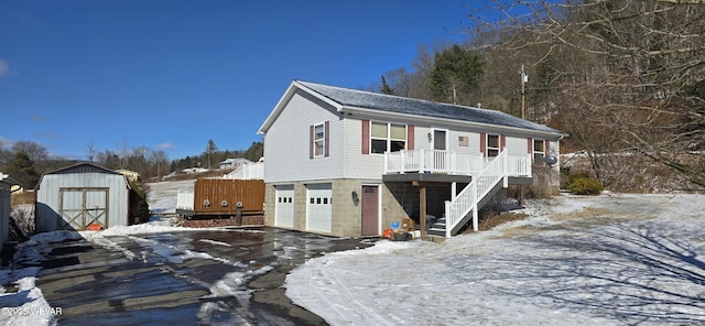 view of front of property with a garage and a shed