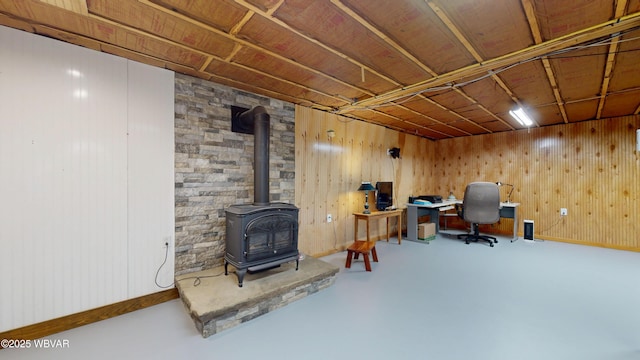 office space featuring concrete flooring and a wood stove