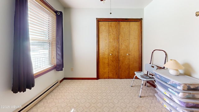 interior space featuring a baseboard heating unit and light colored carpet