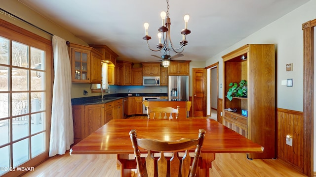 dining room featuring sink, a wealth of natural light, an inviting chandelier, and light hardwood / wood-style flooring