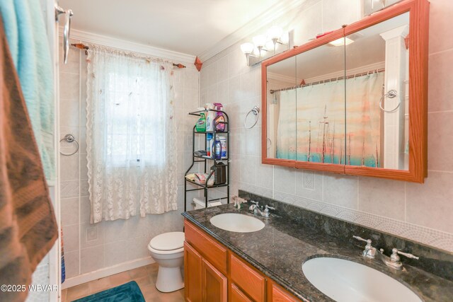 bathroom featuring tile walls, ornamental molding, a sink, and toilet