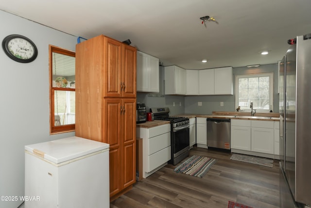 kitchen featuring dark wood finished floors, white cabinets, recessed lighting, and stainless steel appliances