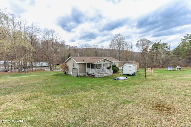 view of front of home featuring a front lawn, an outdoor structure, and a storage shed