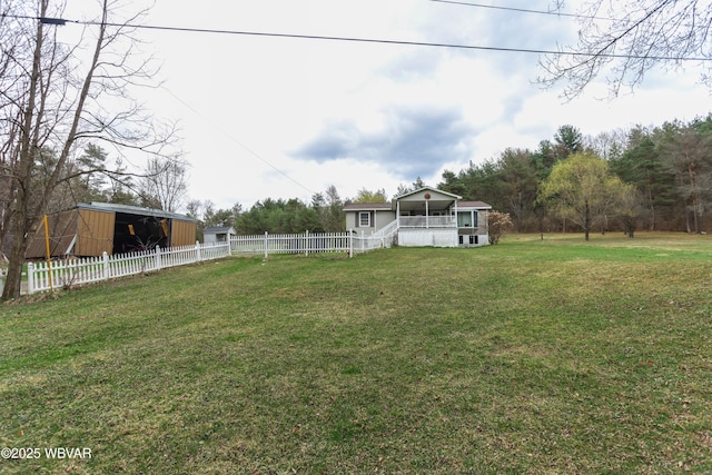 view of yard featuring an outbuilding, fence, and a pole building