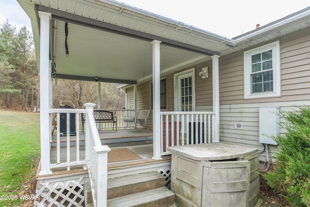 wooden deck featuring covered porch and a yard