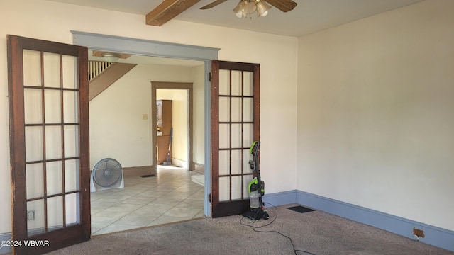 spare room with beamed ceiling, ceiling fan, and light colored carpet