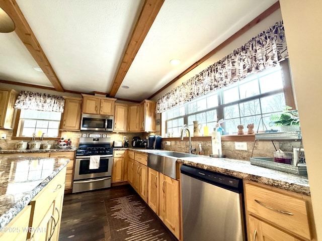 kitchen with dark wood-style flooring, a sink, stainless steel appliances, beamed ceiling, and backsplash