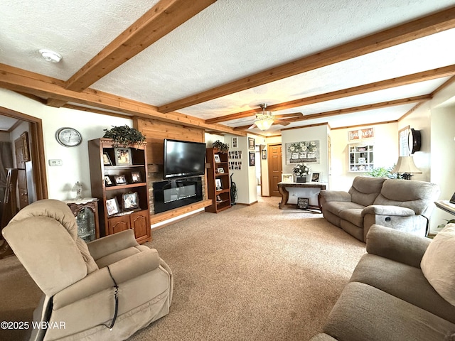 living area with beam ceiling, light carpet, a glass covered fireplace, a textured ceiling, and a ceiling fan