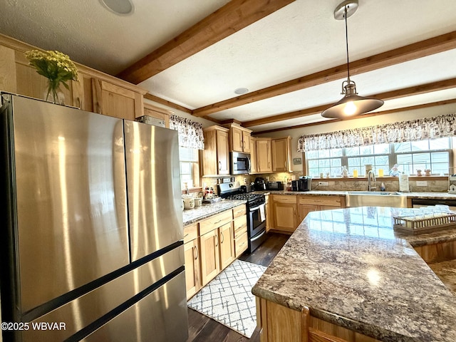 kitchen featuring dark wood-style floors, a sink, hanging light fixtures, appliances with stainless steel finishes, and beamed ceiling