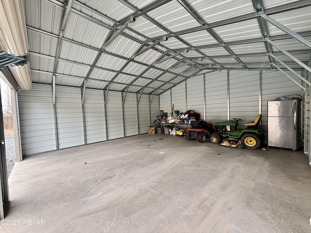 garage with metal wall and freestanding refrigerator