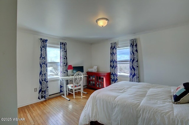 bedroom featuring ornamental molding and wood finished floors