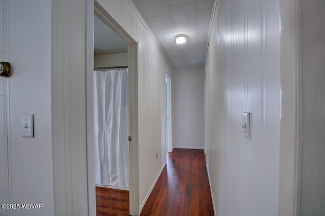 corridor with dark wood finished floors and baseboards