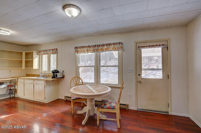 dining area with dark wood-type flooring and baseboards