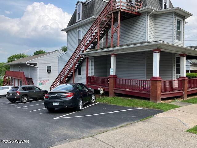 130 N Fairview St, Lock Haven, PA 17745 - view of side of home featuring stairway, mansard roof, uncovered parking, and roof with shingles