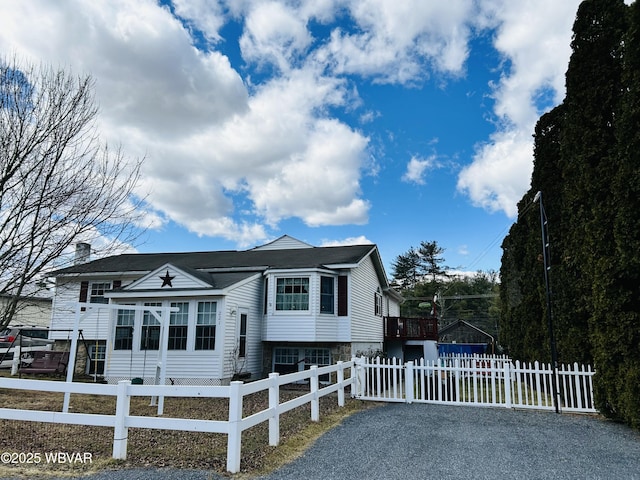 view of front of house with a fenced front yard and gravel driveway