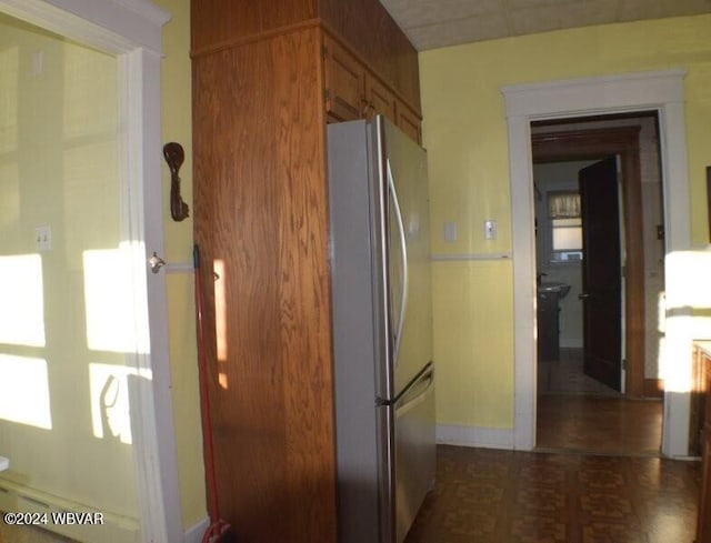 kitchen with dark parquet floors and stainless steel refrigerator