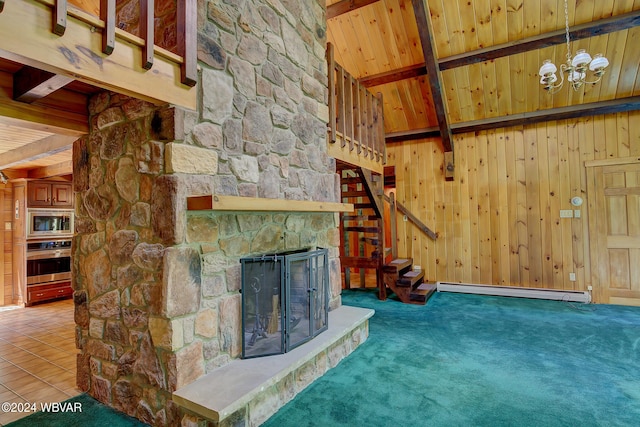 unfurnished living room with a baseboard heating unit, wood walls, beamed ceiling, and a fireplace