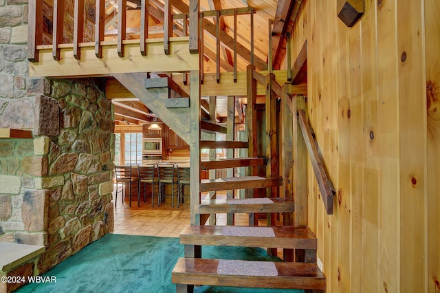 stairs with carpet flooring and beamed ceiling