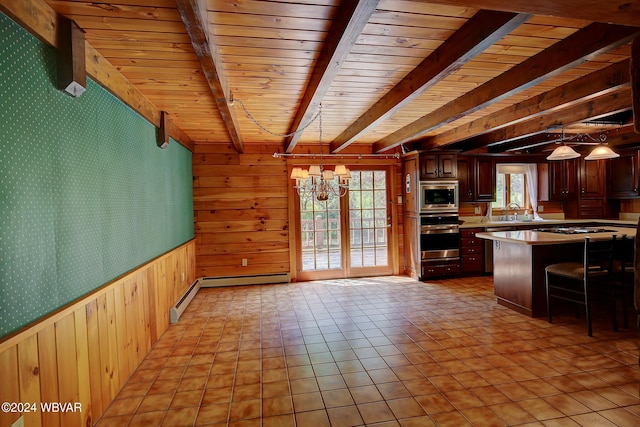 kitchen featuring a notable chandelier, light countertops, appliances with stainless steel finishes, beamed ceiling, and wallpapered walls