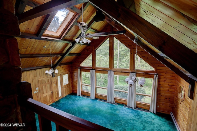 interior space with a notable chandelier, lofted ceiling with skylight, carpet flooring, wooden walls, and wooden ceiling