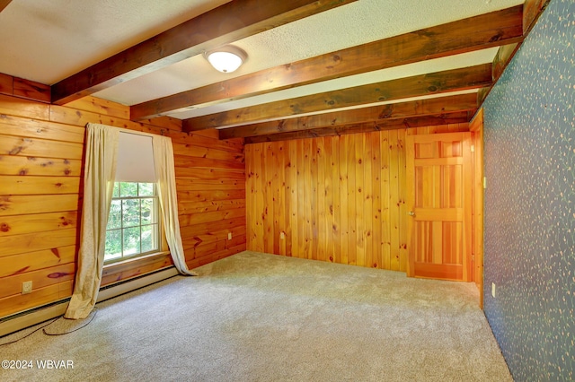 carpeted spare room with beam ceiling, wooden walls, and baseboard heating