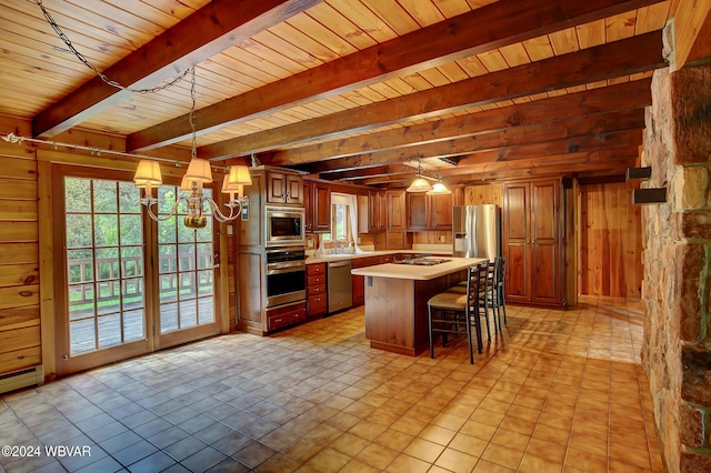 kitchen featuring stainless steel appliances, light countertops, wood walls, and a sink