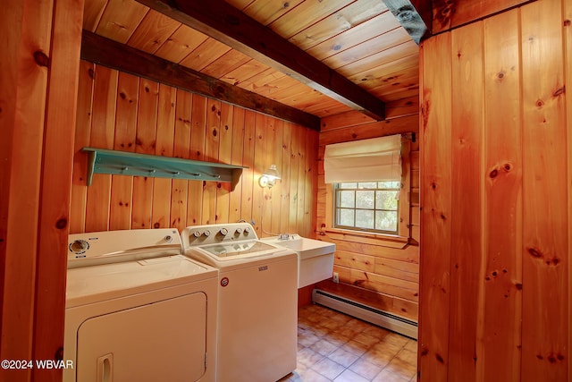 clothes washing area with laundry area, wooden ceiling, washing machine and clothes dryer, wood walls, and a baseboard heating unit