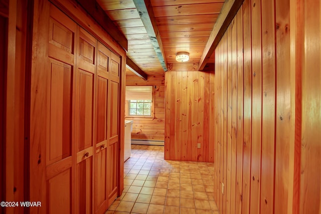 corridor with wooden ceiling, light tile patterned flooring, wood walls, baseboard heating, and beamed ceiling