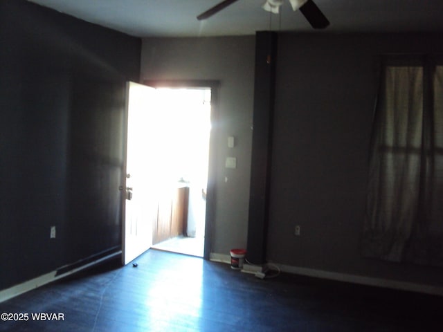 unfurnished room with baseboards, ceiling fan, and wood finished floors