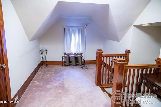 additional living space with radiator, vaulted ceiling, and carpet flooring