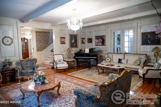 living room with beam ceiling, hardwood / wood-style flooring, ornamental molding, and a chandelier