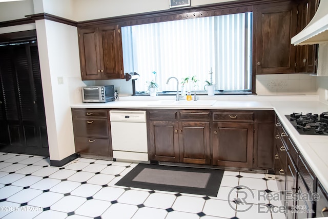 kitchen with premium range hood, dark brown cabinetry, sink, dishwasher, and black gas cooktop