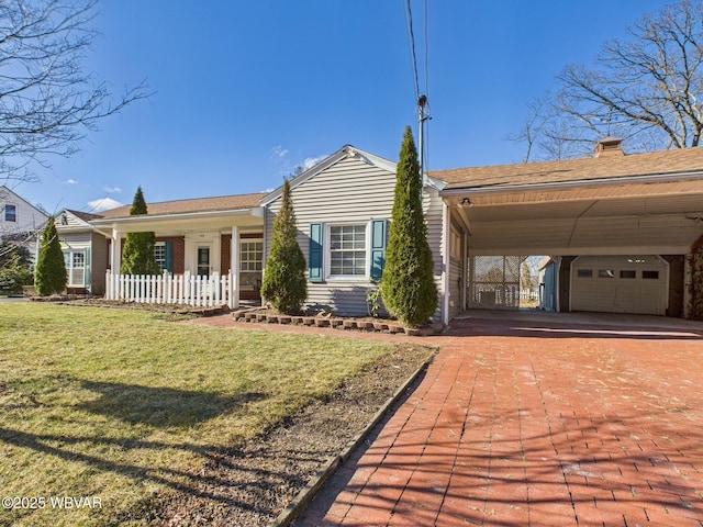 view of front of property featuring a garage, decorative driveway, and a front yard