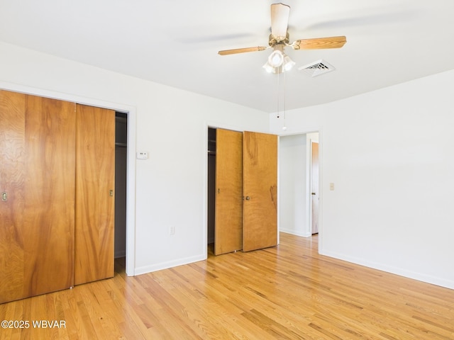 unfurnished bedroom featuring baseboards, visible vents, ceiling fan, and light wood finished floors