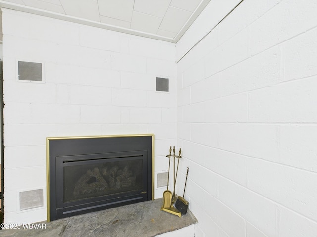 interior details with a glass covered fireplace and visible vents