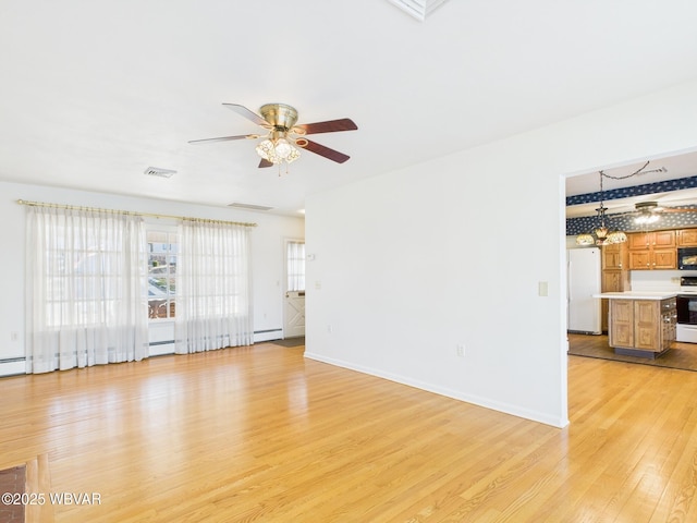 unfurnished living room with visible vents, baseboards, ceiling fan, light wood-type flooring, and a baseboard heating unit