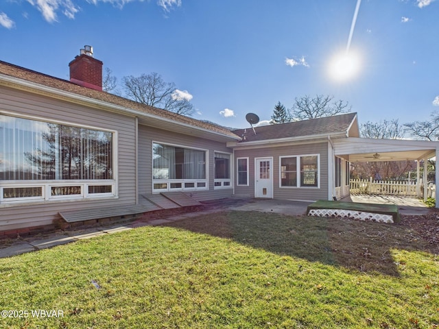 rear view of house featuring a patio area, a lawn, and a chimney