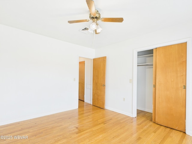 unfurnished bedroom featuring a ceiling fan, light wood-type flooring, a closet, and baseboards