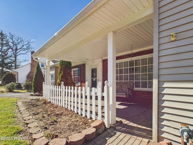 exterior space featuring a porch and brick siding