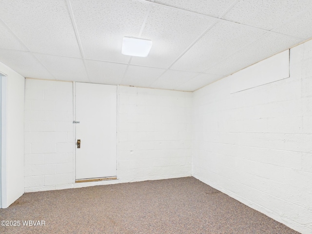 finished basement featuring carpet floors, concrete block wall, and a drop ceiling