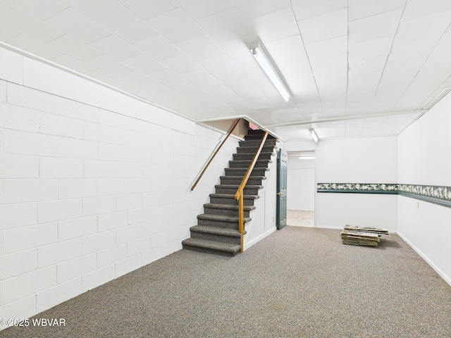 finished basement featuring stairway, carpet flooring, and baseboards