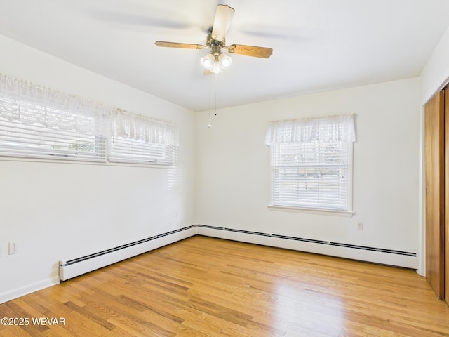 empty room featuring ceiling fan, a baseboard radiator, and light wood-style floors