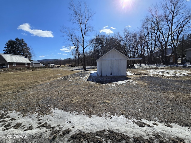 snowy yard featuring a storage unit