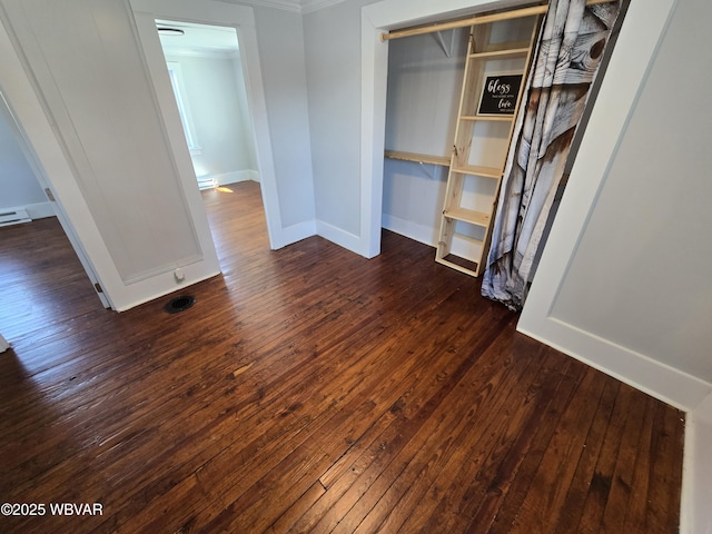 unfurnished bedroom with dark hardwood / wood-style floors and a closet