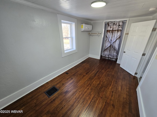 unfurnished bedroom featuring crown molding, dark wood-type flooring, and a wall mounted AC