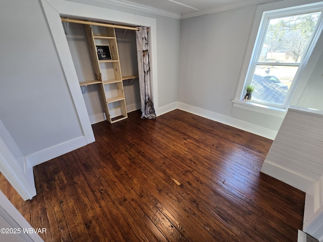 unfurnished bedroom with a closet, ornamental molding, and dark hardwood / wood-style floors