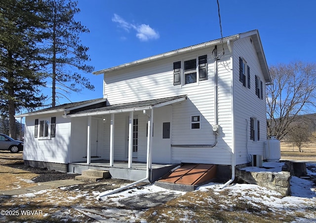 snow covered property with covered porch